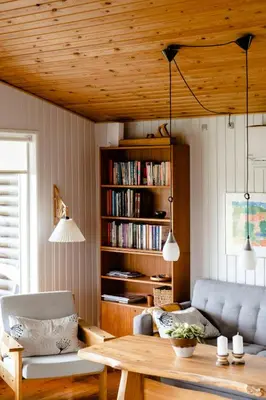 a living room with a table and a book shelf at Authentic Family Summer House At The Limfjord in Roslev