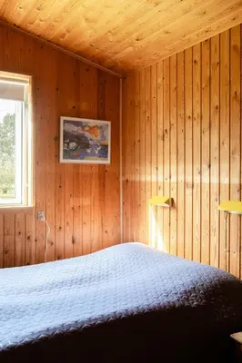 a bedroom with a bed in a wooden wall at Authentic Family Summer House At The Limfjord in Roslev