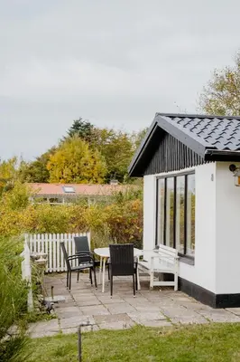 a patio with chairs and a table and a building at Summer House With Panoramic Views Of The Limfjord in Lihme