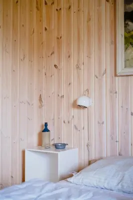 a bedroom with a bed and a wooden wall at Family Home In Heather-Clad Landscape in Fjerritslev