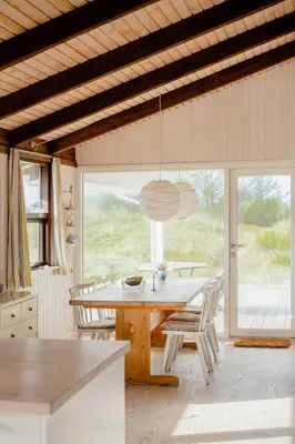 a kitchen with a table and chairs and a large window at Family Home In Heather-Clad Landscape in Fjerritslev