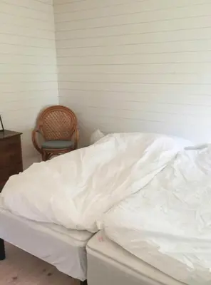 an unmade bed in a room with a chair at Architect-Designed House By Limfjord in Thyholm