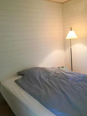 a bedroom with a bed next to a lamp at Architect-Designed House By Limfjord in Thyholm