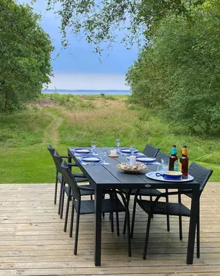 a black table with chairs and drinks on a deck at Architect-Designed House By Limfjord in Thyholm