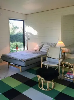 a bedroom with a bed and a chair and a window at Architect-Designed House By Limfjord in Thyholm