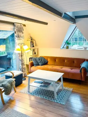 a living room with a couch and a table at Summerhouse By The North Sea in Vestervig