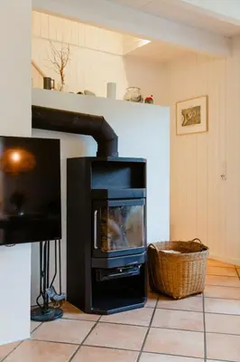 a fireplace in a living room with a stove at Family Summer House Close To The North Sea in Vestervig