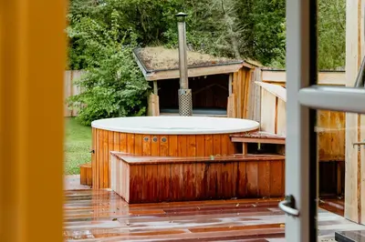 a bath tub in a wooden house with a sink at Family Summer House Close To The North Sea in Vestervig
