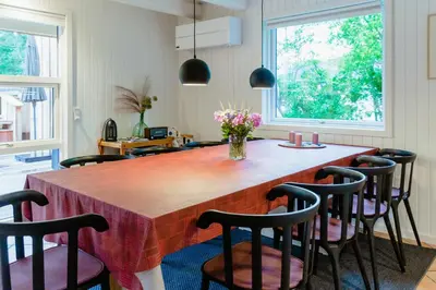a kitchen with a large wooden table with chairs at Family Summer House Close To The North Sea in Vestervig