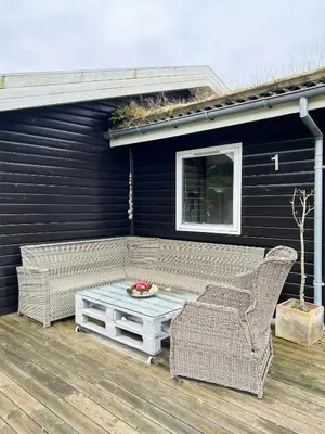 a patio with a couch and a table and chairs at Creative Family House Near Blokhus Beach in Blokhus