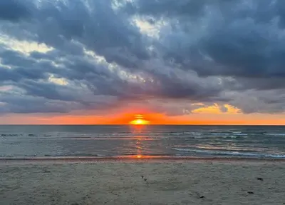 a sunset on a beach with the ocean and clouds at Creative Family House Near Blokhus Beach in Blokhus
