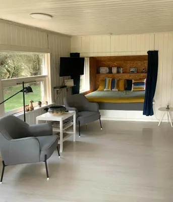 a bedroom with a bed and two chairs and a table at North Sea's Expanse Near Vorupør in Thisted