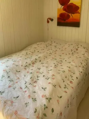 a bed with a floral comforter in a bedroom at North Sea's Expanse Near Vorupør in Thisted