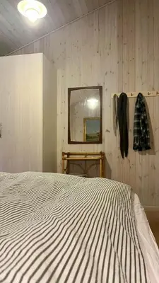 a bedroom with a large bed and a mirror at Holiday Home In Tranum Forest in Brovst