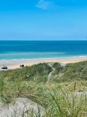 a beach with a car and the ocean in the background at Family House At Kryle Klit Near Wild Nature in Blokhus