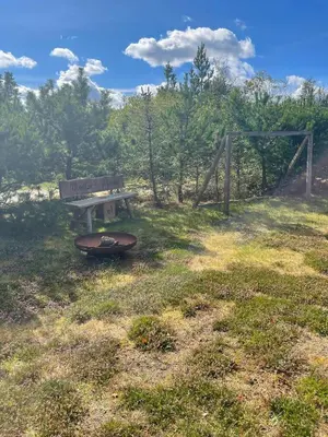 a park bench and a surfboard sitting in a field at Family House At Kryle Klit Near Wild Nature in Blokhus