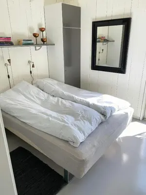 a bedroom with two beds with a mirror on the wall at Personlighed Arkitekttegnet Hus Ved Spøttrup in Spottrup