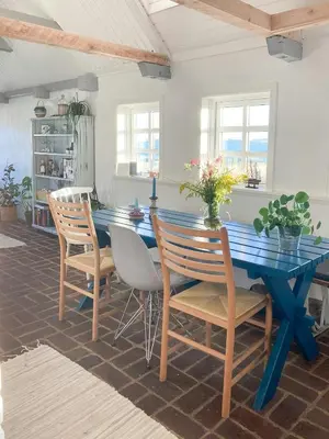 a dining room with a blue table and chairs at Historic House With Fjord View On Venø in Vemb