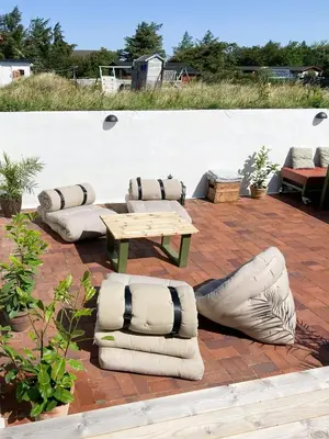 a patio with a table and pillows and a table and chairs at Historic House With Fjord View On Venø in Vemb