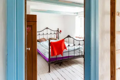 a bedroom with a bed with a red towel on it at Magical Farm House Right Next To The Sea in Lemvig