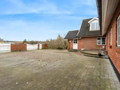 a brick house with a large driveway in front of it at Holiday Home Star - 200m to the fjord by Interhome in Farsø