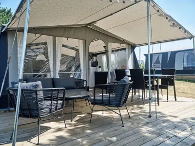 a group of chairs and tables under a tent at Toftum Bjerge Camping & Cottages in Humlum