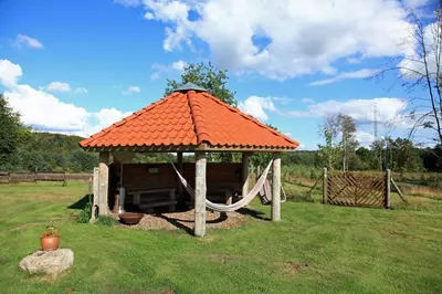 a gazebo with an orange roof and a swing at Alt det bedste mellem hav og fjord - en hel bolig in Brovst