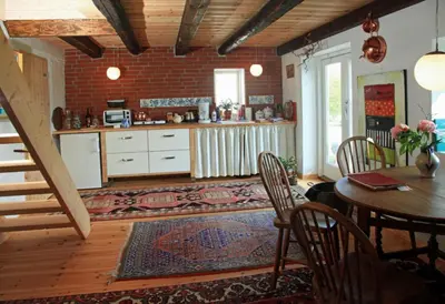 a kitchen and dining room with a table and chairs at Alt det bedste mellem hav og fjord - en hel bolig in Brovst