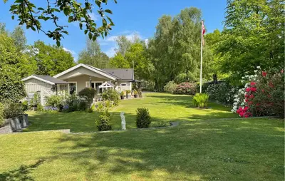 a house with a flag in the yard at Amazing Home In Højslev With Sauna in Højslev