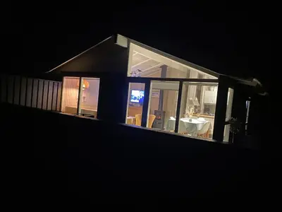 a house at night with a table and chairs at Sommerhus i Rødhus Blokhus in Pandrup