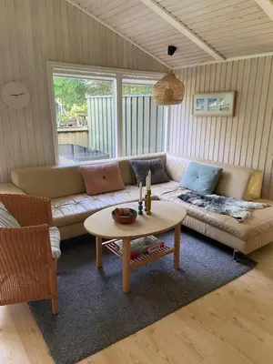a living room with a couch and a table at Sommerhus i Rødhus Blokhus in Pandrup