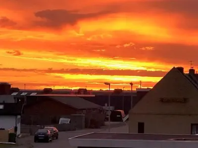 a sunset over a parking lot with a car at Svanegade 1 , 2 sal in Thyborøn