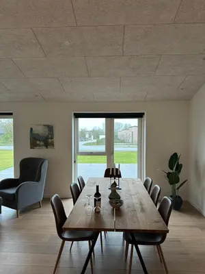 a dining room with a wooden table and chairs at Moderne nybygget in Holstebro