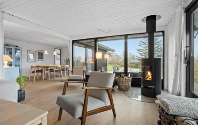 a living room with a fireplace and a table and chairs at Amazing Home In Spøttrup With Wifi in Lihme