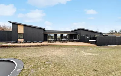 a black house with a large yard in front of it at Nice Home In Højslev With Sauna in Højslev