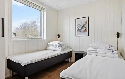 two beds in a room with a window at Nice Home In Højslev With Sauna in Højslev