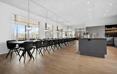 a dining room with a long table and black chairs at Nice Home In Højslev With Sauna in Højslev