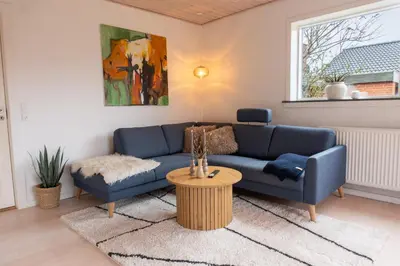 a living room with a blue couch and a table at Villa Holstebro in Holstebro