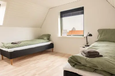a bedroom with two beds and a window at Villa Holstebro in Holstebro