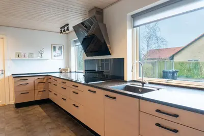 a kitchen with a sink and a large window at Villa Holstebro in Holstebro