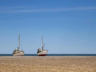 two boats are sitting on the beach at 6 person holiday home in Brovst in Brovst