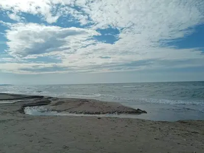 a beach with a cloudy sky and the ocean at 6 person holiday home in Brovst in Brovst