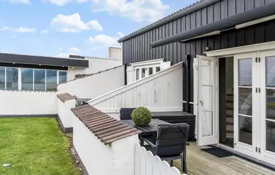 a patio with a table and chairs on a house at Gorgeous Home In Vestervig With Sauna in Vestervig