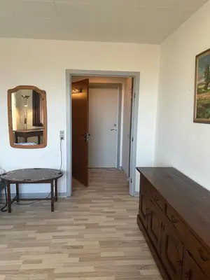 a room with a table and a mirror and a door at Hostel Mors in Erslev