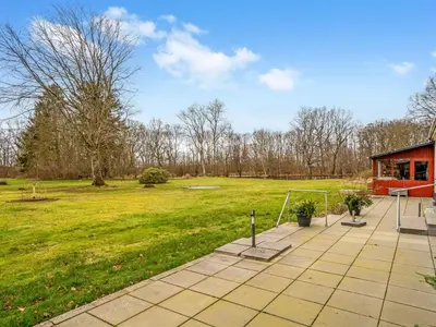 a patio with a building and a grass field at Holiday Home Eva - 9km to the fjord by Interhome in Brovst