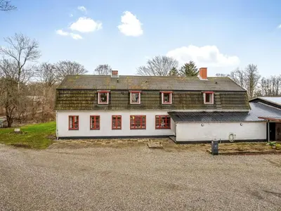 a large white house with a green roof at Holiday Home Eva - 9km to the fjord by Interhome in Brovst
