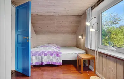 a small bedroom with a bed and a window at Two-Bedroom Holiday Home Thyholm With Sea View 04 in Thyholm