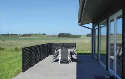 a table and chairs on a porch of a building at Three-Bedroom Holiday Home Hurup Thy With A Fireplace 06 in Sindrup