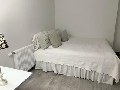 a bedroom with a bed with white sheets and pillows at Blokhus Beach House in Blokhus