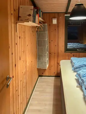 a small room with a bed and a window at Charming Wooden Summer House In Trend in Løgstør